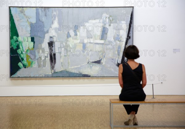 Woman looking at a painting, L’Orchestre, 1953. Nicolas de Staël.  Centre George Pompidou. Musee National d'Art Moderne.  Paris. France