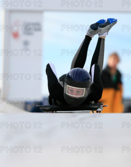 A skeleton racer dives down a track