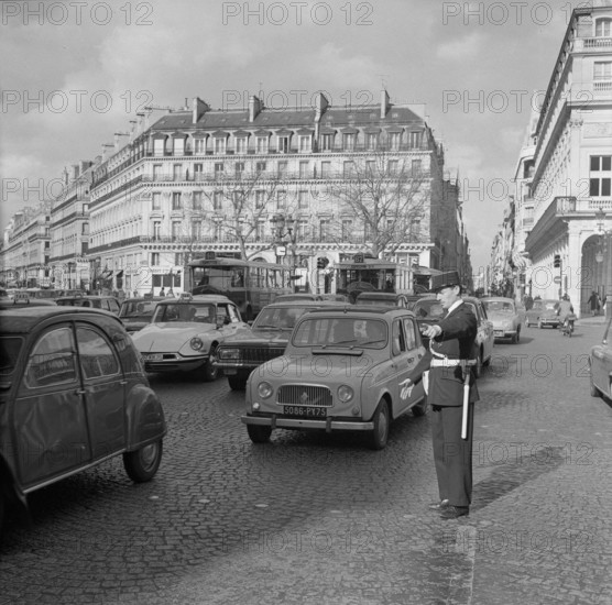 Pariser Bilder [The street life of Paris] Description: Agent regulates traffic Date: 1965 Location: France, Paris Keywords: cars, street images, traffic police