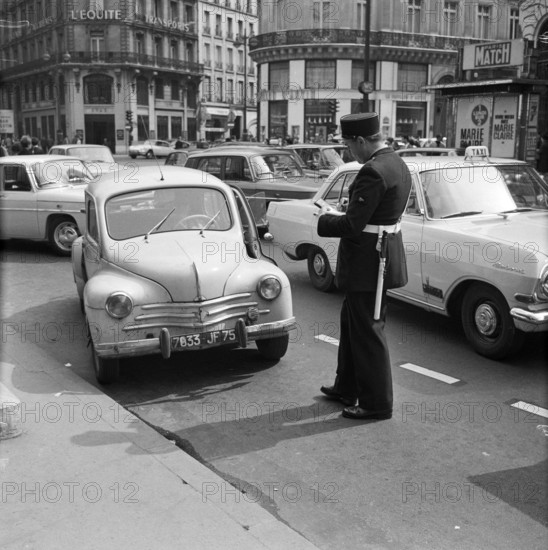 Pariser Bilder [The street life of Paris] Description: Agent writes a ticket from Date: 1965 Location: France, Paris Keywords: cars, fines, street images, traffic police