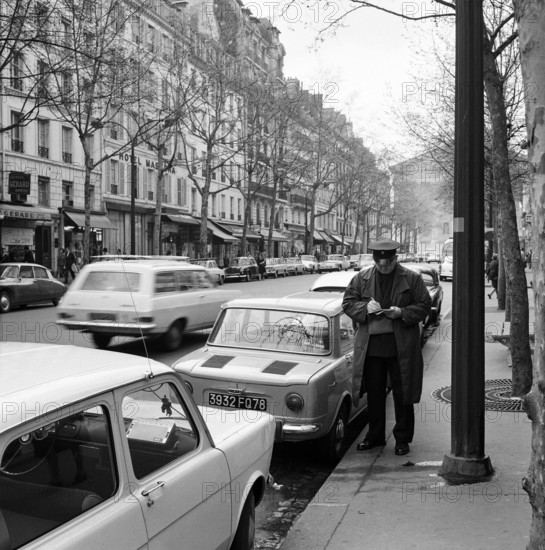 Pariser Bilder [The street life of Paris] Description: Agent writes a ticket from Date: 1965 Location: France, Paris Keywords: cars, fines, street images, traffic police
