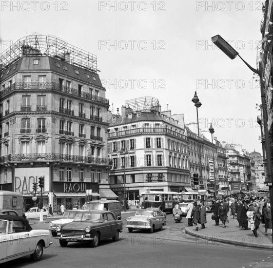 Pariser Bilder [Paris Street Life] Description: Cars and pedestrians on Boulevard Hausmann Date: 1965 Location: France, Paris Keywords: cars, buildings, street sculptures, pedestrians, shops