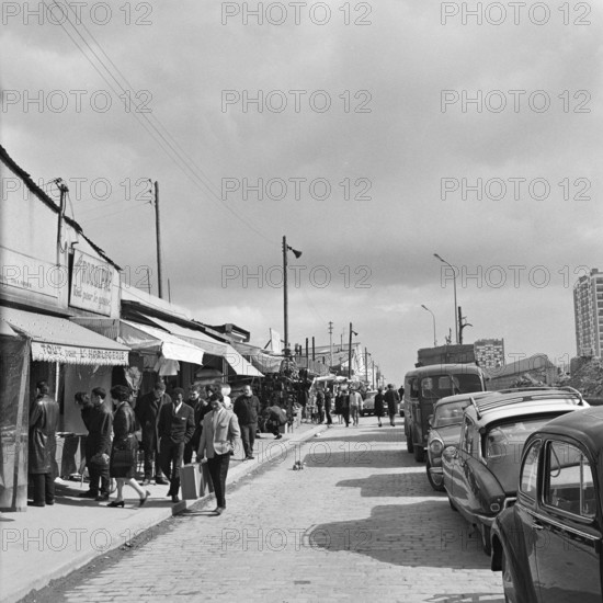 Pariser Bilder [The street life of Paris] Description: Visitors to a flea market along displayed merchandise Date: 1965 Location: France, Paris Keywords: street images, flea markets