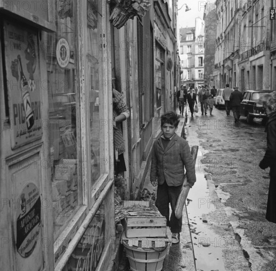 Pariser Bilder [The street life of Paris]  Boy with baguette Date: 1965 Location: France, Paris Keywords: groceries, bread, children, street images
