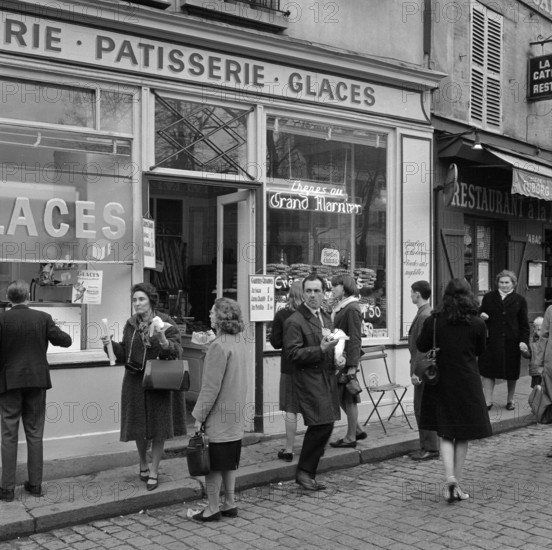 Pariser Bilder [Paris Street Life]  Customers on the sidewalk in front of a pastry shop Date: 1965 Location: France, Paris Keywords: confectioners, pastries, street statues, shops