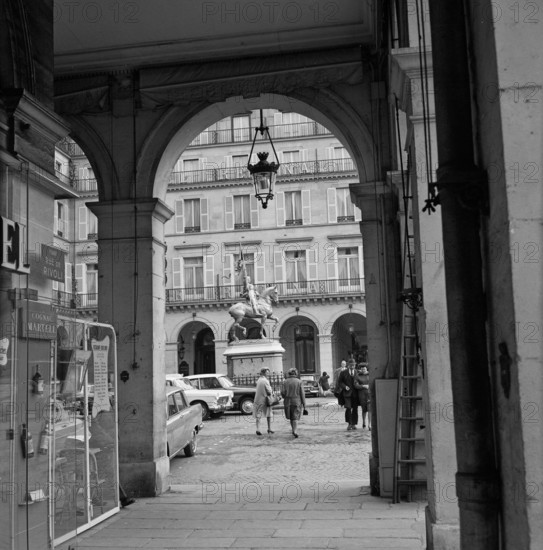 Pariser Bilder [The street life of Paris]  Place des Pyramides seen from the Rue de Rivoli, with in the background Hôtel Regina and the statue of Joan of Arc Date: 1965 Location: France, Paris Keywords: buildings, hotels, statues, street statues