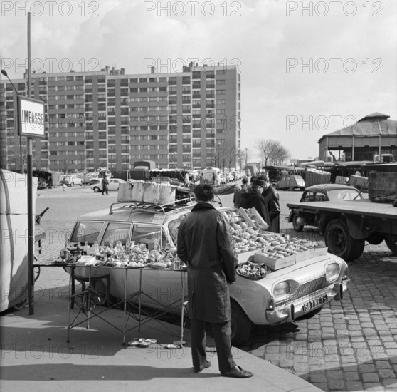 Pariser Bilder [The street life of Paris]  Portrait on the hood of a car Date: 1965 Location: France, Paris Keywords: cars, market merchants, street images, flea markets
