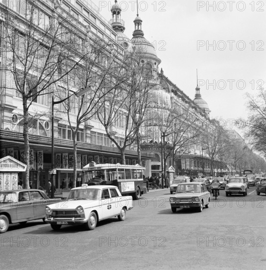 Pariser Bilder [The street life of Paris]  Department stores Printemps and Lafayette on Boulevard Hausmann Date: 1965 Location: France, Paris Keywords: cars, buildings, street statues, department stores