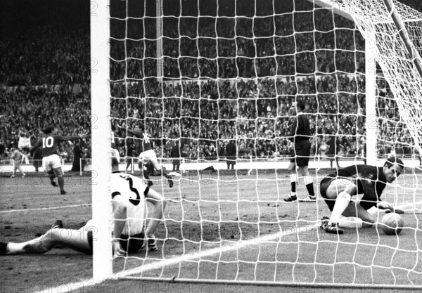 England versus West Germany 1966 World Cup Final, Wembley Stadium England's Martin Peters turns to celebrate his 18th minute goal with Geoff Hurst and Roger Hunt as West Germany's Hans Tilkowski picks the ball out of the net and Number 3, Karl-Heiz Schnellinger is left on the deck  Photo by Tony Henshaw Archive