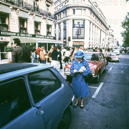 Traffic policeman checks parked cars, Paris; France, 1978