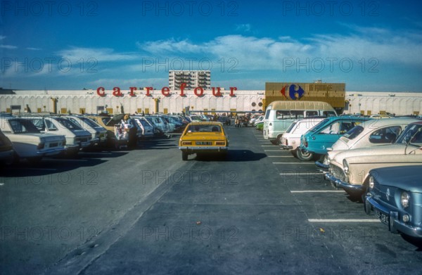 1970s archive image of car park in front of a Carrefour hypermarket in the South of France.  Believed to be Carrefour La Ciotat.