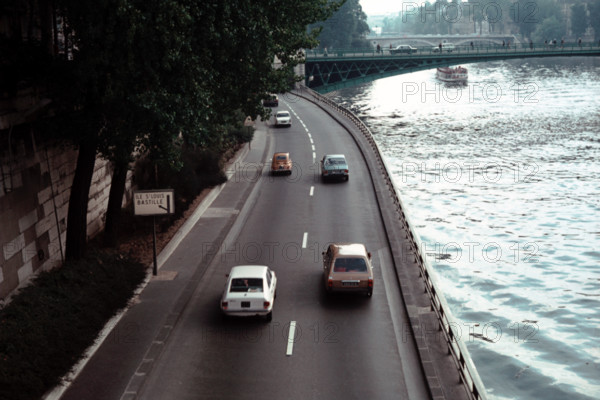 Sparse traffic on the road alongside the Seine river in Paris during the 1970s