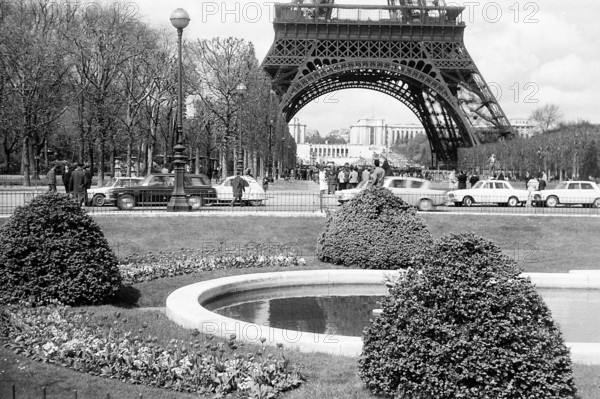 This photograph of the Eiffel Tower taken in 1965 captures the iconic structure in a timeless image, symbolizing both the engineering marvel and cultural significance of Paris. The Eiffel Tower, completed in 1889, remains a global symbol of France.