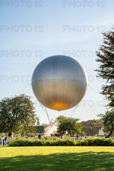 Olympic cauldron topped by a hot air balloon in Jardin des Tuileries with tourists around, during Paris 2024 Summer Olympics celebration, Paris France