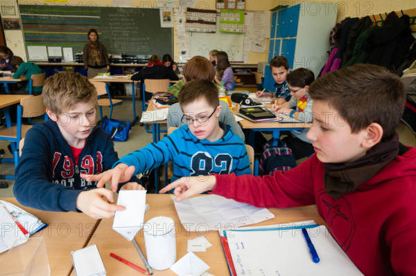 Non-disabled and disabled pupils (in this case a boy suffering from Down's syndrome) learn together in the same class.