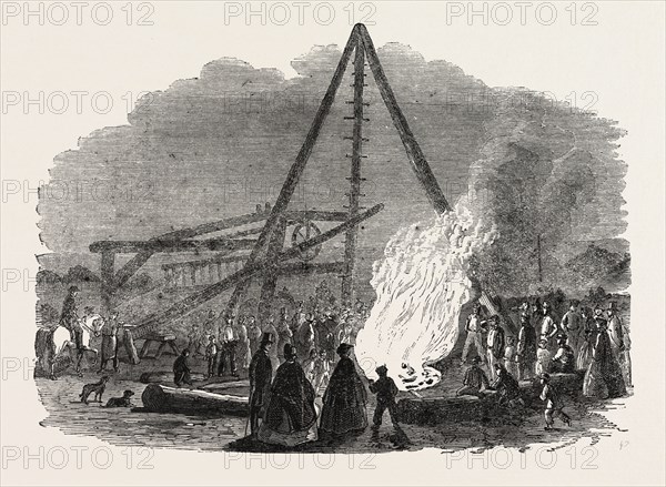 THE BURNING WELL NEAR THE FEATHERSTONE STATION IN THE VICINITY OF PONTEFRACT. In boring for coal, the sinkers penetrated a bed of shale at a depth of about 120 feet, upon which the water previously rising through the borehole was suddenly ejected like a fountain to the height, it is said, of 30 feet above the surface of the earth, impelled by the violent efflux of gas which the perforation had liberated from its cavernous laboratory; and, on the application of a lighted match (after the subsidence of the jet) near the surface of the water, which covered the orifice, the gas escaping through it instantly took fire, blazing up occasionally to the height of at least three yards, and dancing and flickering in red flames over the well, which heaved and bubbled like a witch's cauldron beneath.
