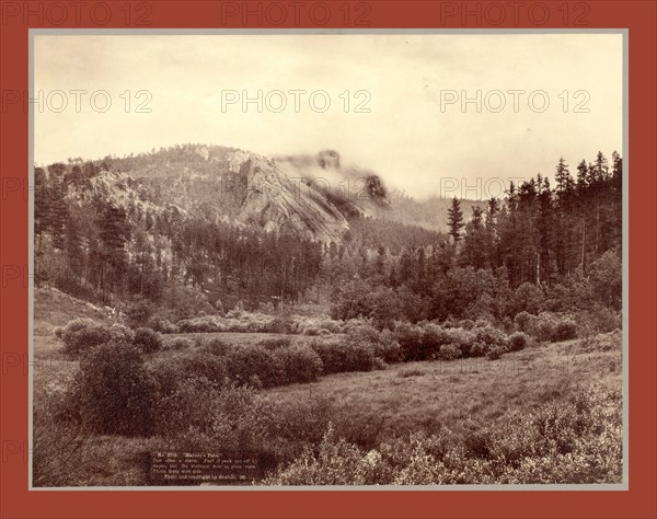Harney's Peak. Just after a storm. Part of Peak cut off by vaper [sic] but the statuary man in plain view. Photo from west side, John C. H. Grabill was an american photographer. In 1886 he opened his first photographic studio