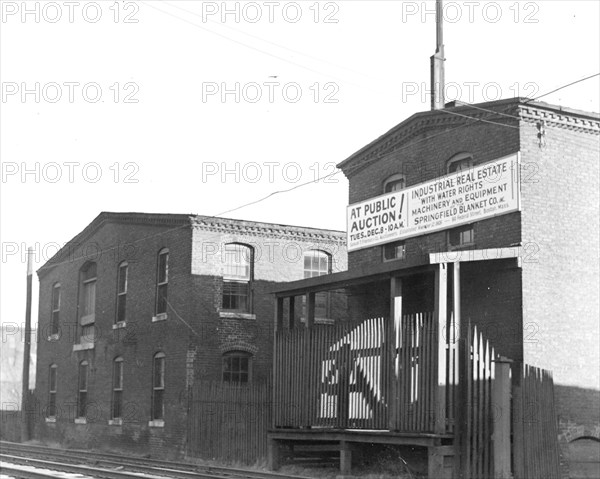 Mt. Holyoke, Massachusetts - Scenes. One of the oldest mills (begun as horse blankets), original site and building, railway track; sold at auction, including mill powers of 250 horsepower, for $1000, down payment, $100 (December 1936) to characteristic new industry, Barashnik of Brooklyn, or Acme Quilting Company who is to make dining table pads; machinery bought $22,000. Springfield Blanket Company, 1936, Lewis Hine, 1874 - 1940, was an American photographer, who used his camera as a tool for social reform. US,USA