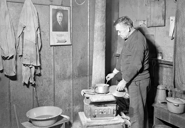 Scott's Run, West Virginia. Unemployed bachelor, Jere - This is typical of a particular group of stranded men in an abandoned camp. He speaks English badly but indicated that the government was interested in his welfare by indicating the pictures on the wall, March 1937, Lewis Hine, 1874 - 1940, was an American photographer, who used his camera as a tool for social reform. US,USA