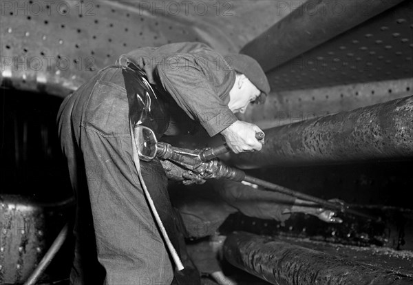 Eddystone, Pennsylvania - Railroad parts. Baldwin Locomotive Works. Boilermaker tapping for stay-bolts in boiler of a modern locomotive, March 1937, Lewis Hine, 1874 - 1940, was an American photographer, who used his camera as a tool for social reform. US,USA