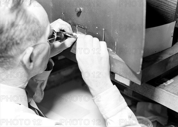 Lancaster, Pennsylvania - Hamilton Watches. Operation - truing balance wheels - a skilled machine operation - balance wheel is placed into calipers provided with an index which shows where a wheel is out of balance - right hand (with or without a small tool, adjusts the balance), 1936, Lewis Hine, 1874 - 1940, was an American photographer, who used his camera as a tool for social reform. US,USA