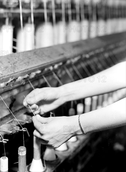 High Point, North Carolina - Textiles. Pickett Yarn Mill. Spinning - Saco-Lowell machine - showing hands of woman in operation - highly skilled, January 1937, Lewis Hine, 1874 - 1940, was an American photographer, who used his camera as a tool for social reform. US,USA
