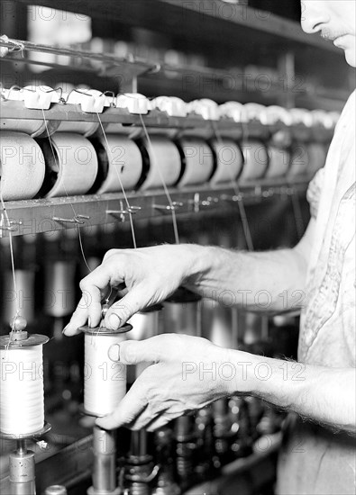 Paterson, New Jersey - Textiles. Rayon yarn being wound from one bobbin on to another and being twisted, March 1937, Lewis Hine, 1874 - 1940, was an American photographer, who used his camera as a tool for social reform. US,USA