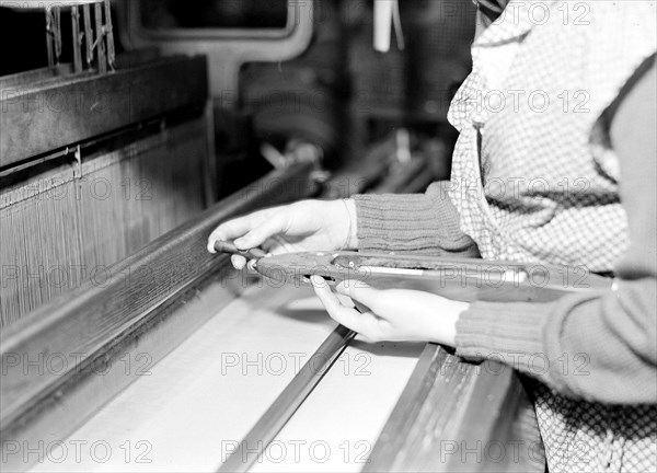 Paterson, New Jersey - Textiles. Weaver threading shuttle, March 1937, Lewis Hine, 1874 - 1940, was an American photographer, who used his camera as a tool for social reform. US,USA