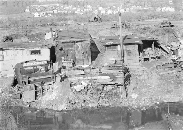 Paterson, New Jersey - Textiles. Bachelor shacks in outskirts of Paterson, on Molly Jan Brook. About 20 men live there now (some of them old silk workers) and stay up there all winter. Man in one view worked in silk up to 5 years ago. On relief now, March 1937, Lewis Hine, 1874 - 1940, was an American photographer, who used his camera as a tool for social reform. US,USA