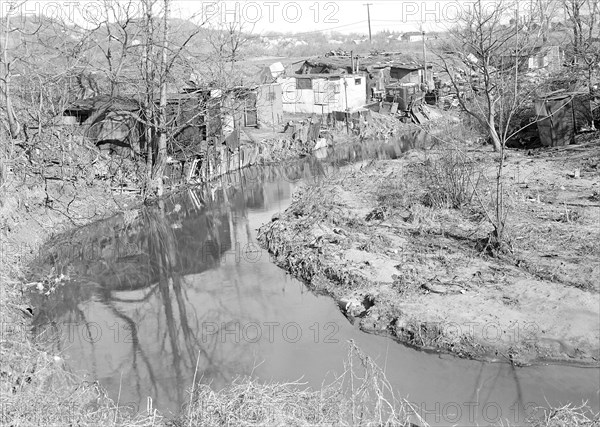 Paterson, New Jersey - Textiles. Bachelor shacks in outskirts of Paterson, on Molly Jan Brook. About 20 men live there now (some of them old silk workers) and stay there all winter. Man in one view worked in silk up to 5 years ago. On relief now, March 1937, Lewis Hine, 1874 - 1940, was an American photographer, who used his camera as a tool for social reform. US,USA