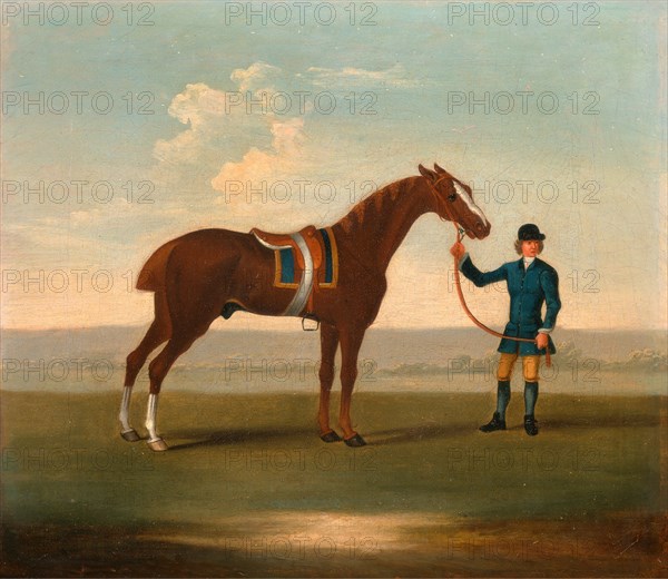 One of Four Portraits of Horses - a Chestnut Horse (? Old Partner) held by a Groom: standing facing right, wearing blue saddle-cloth edged with gold; the groom in blue... Racehorse and dismounted Jockey in Blue, Attributed to James Seymour, 1702-1752, British