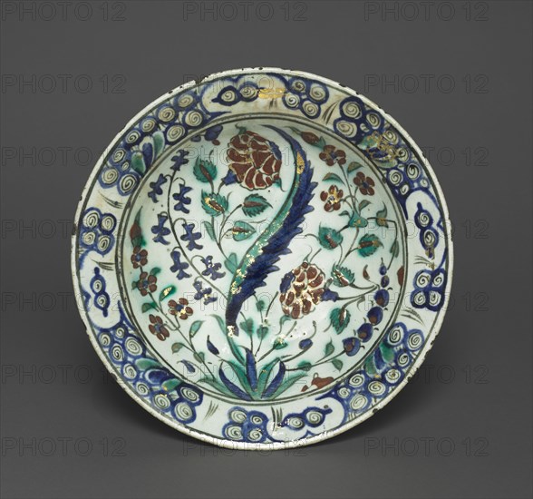 Gilded Dish with Flowers and Leaves, c. 1590. Turkey, Iznik, Ottoman Period, late 16th century. Fritware with red slip, underglaze-painted design, and overglaze gilding; diameter: 29.8 cm (11 3/4 in.); overall: 6.6 cm (2 5/8 in.).