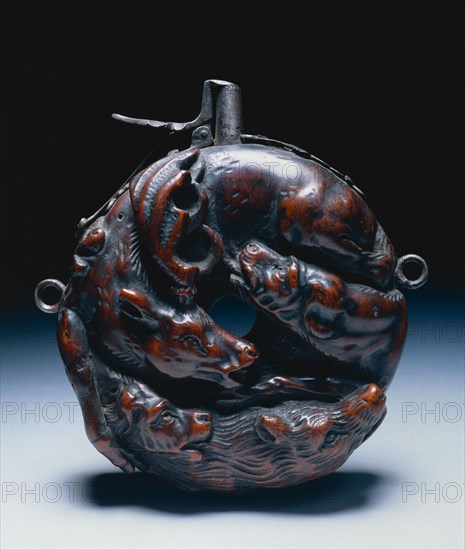 Powder Flask, c. 1680. Johann Michael Maucher (German, 1645-1701). Boxwood with design of stag and hounds carved in high relief; steel funnel, mounts, springcatch; diameter: 13.3 cm (5 1/4 in.); overall: 14.3 cm (5 5/8 in.).