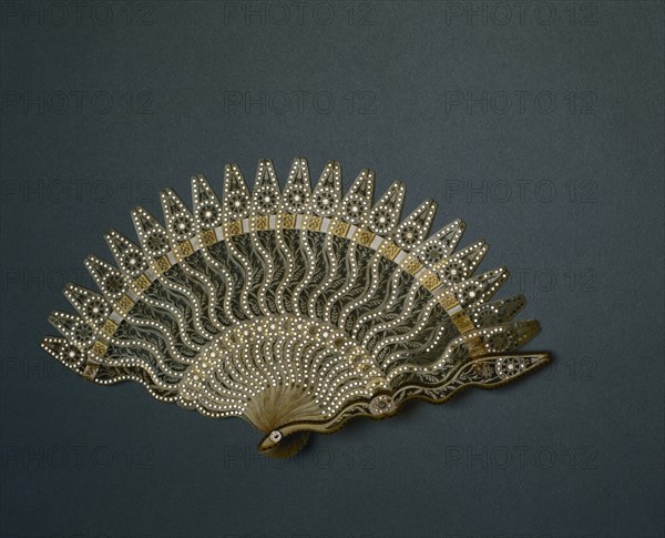 Brisé Fan, c. 1825. France (?), 19th century. Horn, silver-colored metal inlay, silk ribbon; radius: 15.9 cm (6 1/4 in.); spread: 29.2 cm (11 1/2 in.).