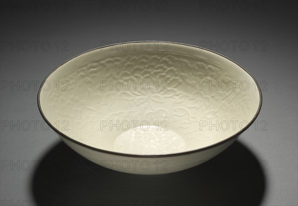 Large Bowl with Peony Scrolls, 1100s. China, Hebei province, Quyang, Jin dynasty (1115-1234). Cream-glazed porcelain with molded design and copper-bound mouth rim, Ding ware; diameter: 26 cm (10 1/4 in.); overall: 8.6 cm (3 3/8 in.).