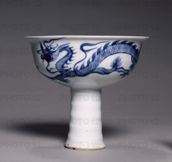 Stem Bowl with Dragon Pursuing Flaming Jewel, 1300s. China, Jiangxi province, Jingdezhen, Yuan dynasty (1271-1368). Porcelain with underglaze blue and molded decoration; diameter: 13.3 cm (5 1/4 in.); overall: 11.8 cm (4 5/8 in.).