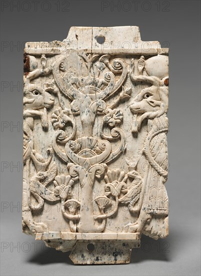 Decorative Plaque: Ram-Headed Sphinxes Flanking a Sacred Tree, 900-800 BC. Phoenician, Iraq, Nimrud, 9th-8th Century BC. Ivory; overall: 15.1 x 9 x 1.1 cm (5 15/16 x 3 9/16 x 7/16 in.).