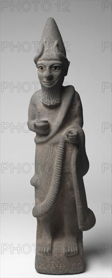 Priest-King or Deity, c. 1600 BC. Hittite, North Syria, early 17th Century BC. Basalt with bone eyes (left, ancient; right, restored); overall: 87.6 cm (34 1/2 in.).