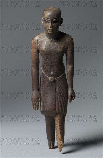 Statuette of a Man, c. 1391-1353 BC. Egypt, New Kingdom, Dynasty 18, reign of Amenhotep III. Ebony inlaid with cobalt blue glass; overall: 23.3 x 6.9 x 4.6 cm (9 3/16 x 2 11/16 x 1 13/16 in.).