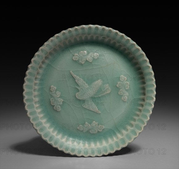 Dish with Flying Crane and Clouds in Relief, 1300s. China, Zhejiang province, Yuan dynasty (1271-1368). Glazed porcelain with molded decoration; diameter: 14.9 cm (5 7/8 in.); overall: 2.4 cm (15/16 in.).