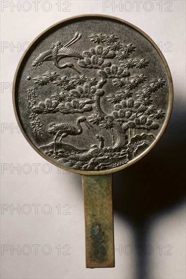 Mirror with Handle, Decorated with Pine Tree and Crane, early 17th - mid 19th century. Japan, Edo (1615-1868). Bronze; diameter: 16.1 cm (6 5/16 in.); overall: 0.4 cm (3/16 in.); rim: 0.4 cm (3/16 in.).
