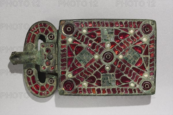 Belt Buckle, c. 525-560. Visigothic, Spain, Migration Period, 6th century. Bronze with garnets, glass, mother of pearl, gold foil, traces of gilding; bronze and glass; overall: 7.1 x 2.7 cm (2 13/16 x 1 1/16 in.).