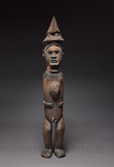 Male Figure, late 1800s-early 1900s. Central Africa, Republic of the Congo (most likely) or Democratic Republic of the Congo, Teke people. Wood, resin, iron, copper, fiber, fabric, cowries, beads, coins, antelope horns; overall: 97.1 cm (38 1/4 in.); without base: 91.5 x 16 x 16.3 cm (36 x 6 5/16 x 6 7/16 in.)