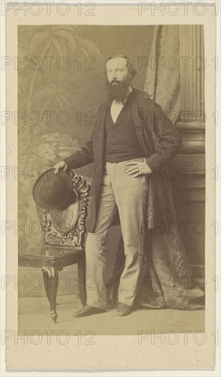 bearded man standing with one hand on hip, the other with hat in hand on chair back; F. Schwarzschild, British, active Calcutta