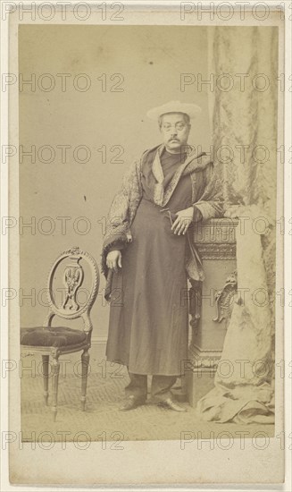 Asian man in robe wearing hat, standing; F. Schwarzschild, British, active Calcutta, India 1860s, 1860s; Albumen silver print