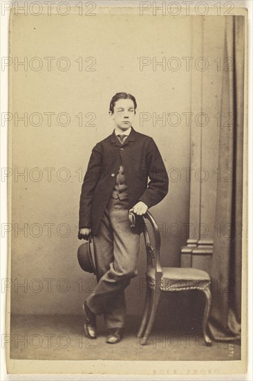 young man with derby in hand, with other hand on chair back, standing; Thomas Edge, British, active 1850s - 1870s, 1865-1870