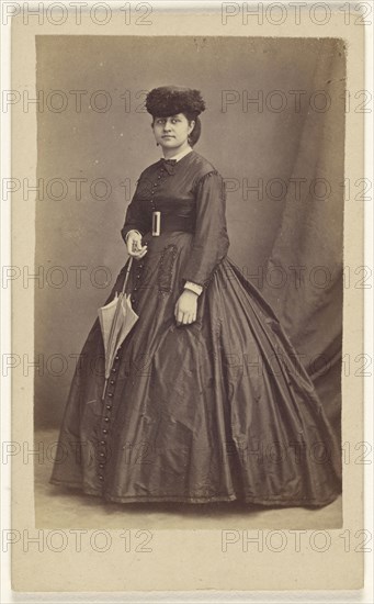 woman wearing a dark hat, holding a parasol, standing; Bailly & Maurice; 1865 - 1870; Albumen silver print