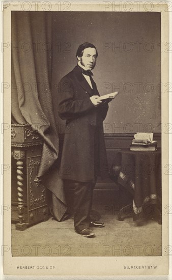 man with long sideburns standing with an open book; Herbert Ogg & Company; about 1865; Albumen silver print