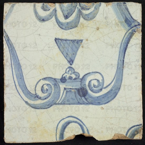 Tile of chimney pilaster, blue on white, part of capital with stylized triangular navel and groin curls of caryatid, chimney