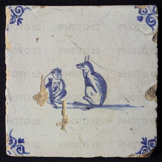 Animal tile, sitting monkey and dog looking at each other, in blue on white, corner pattern ox head, wall tile tile sculpture